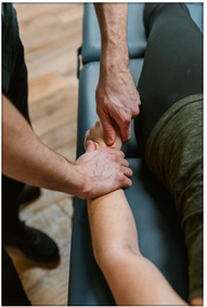 an osteopathic manual therapist treating an arm